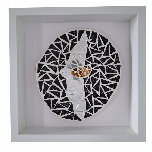 A circular mosaic wall art piece featuring a stylized bat displayed inside a square white shadow box frame. The mosaic is composed of black, white, and silver mirror tiles.