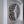 A circular mosaic wall art piece mounted inside a white frame. The design features a black and silver bat.
