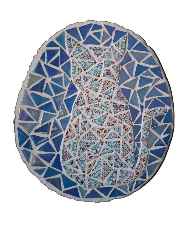 Oval mosaic wall art featuring a stylized cat silhouette design. Crafted with colourful Moroccan patterned ceramic tiles on an iridescent blue background, set on rustic wood.