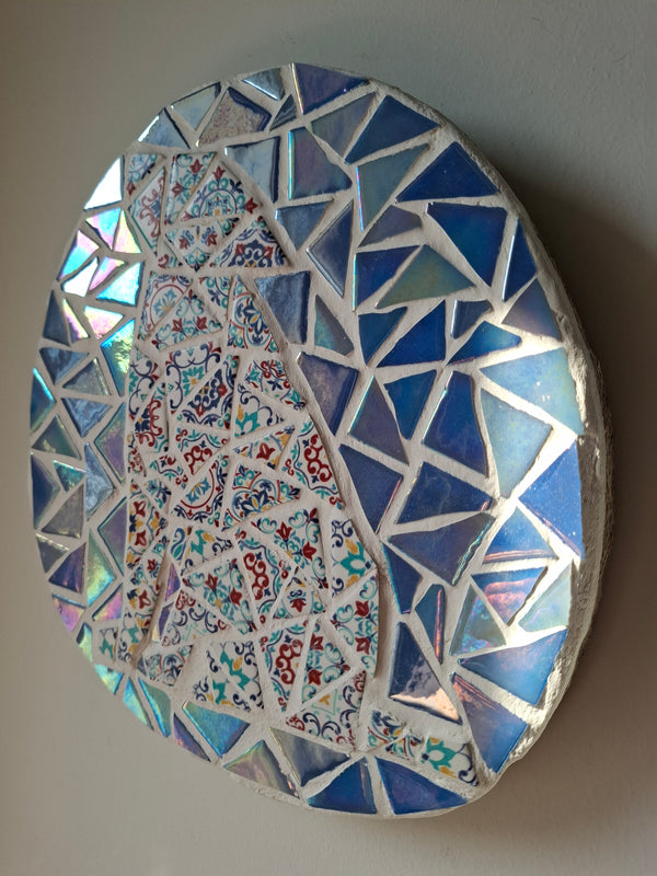 Side view of an oval dog mosaic artwork, showing the rustic wood edge.