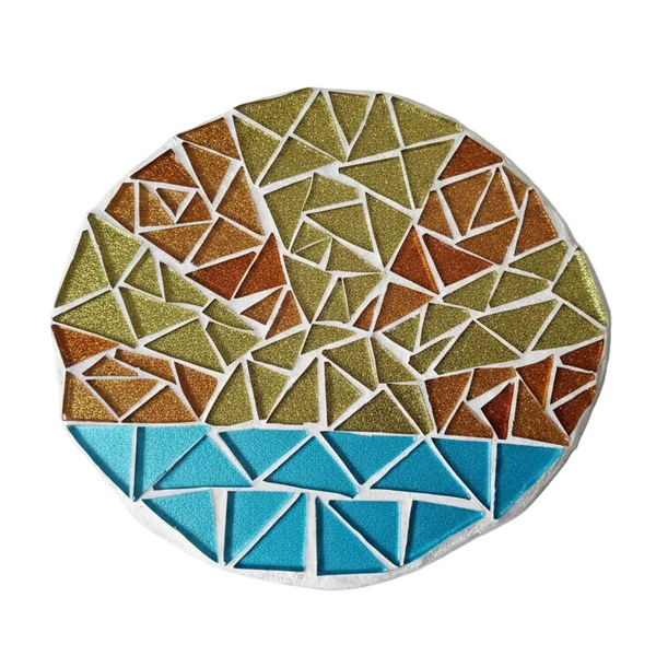 Circular mosaic wall art featuring a stylized sunrise design. Crafted with glittery gold, orange and blue glass pieces, set on rustic wood.