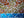 Side view of a circular sunrise mosaic artwork, showing the rustic wood edge.