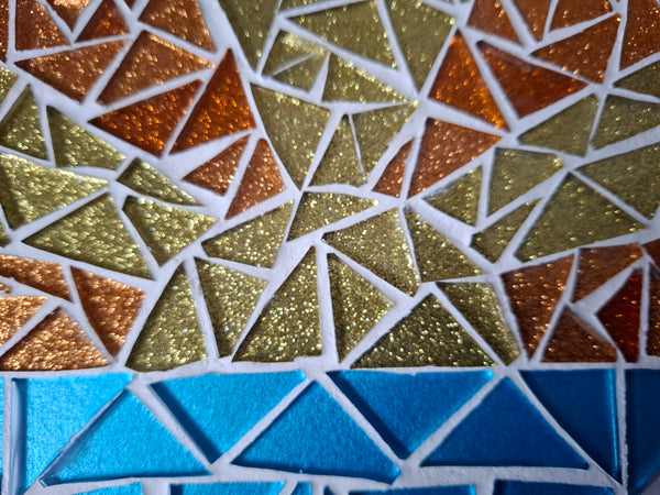 Side view of a circular sunrise mosaic artwork, showing the rustic wood edge.