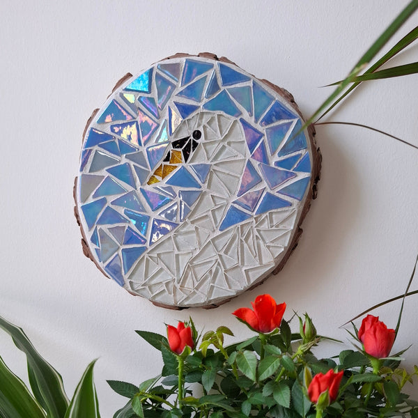 Swan mosaic on the wall surrounded by plants
