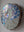 Side view of a circular swan mosaic artwork, showing the rustic wood edge.