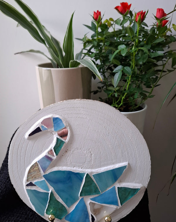 Swan mosaic on the table surrounded by plants 