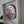 A circular mosaic wall art piece mounted inside a frame. The artwork features a brown dog on a blue background.
