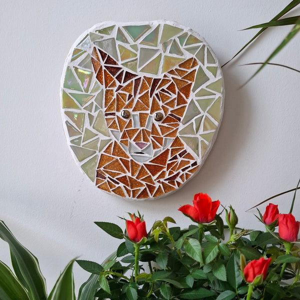 Cat mosaic on the wall surrounded by plants
