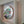 A circular stained glass art piece featuring a stylized parakeet face, mounted on a white frame.