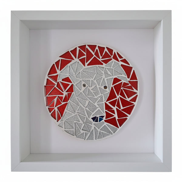A circular mosaic wall art piece depicting a stylized dog face, mounted inside a square white shadow box frame. The mosaic features red and silver geometric tile shapes, with small black and silver accents for the eyes and nose.