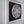 A framed circular mosaic wall art piece featuring a geometric dragonfly design on a dark background, mounted on a white wooden panel.