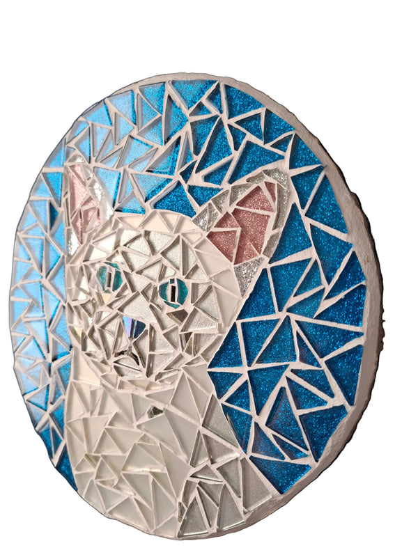Side view of a circular cat mosaic artwork, showing the rustic wood edge.