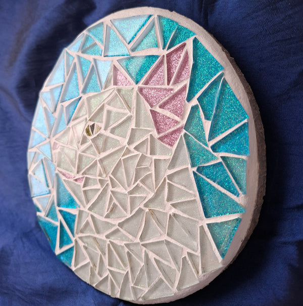 Side view of a circular cat mosaic artwork, showing the rustic wood edge.
