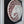 A circular mosaic wall art piece featuring an elephant, crafted with reddish-brown, white and mirrored silver pieces, mounted on a black background inside a white frame.